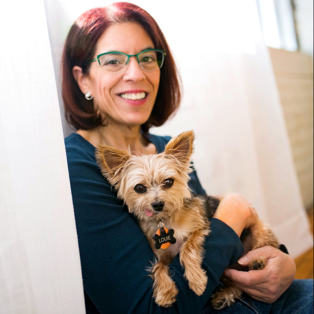 a red short hair middle woman with green glasses and her dog posing a pet photography session