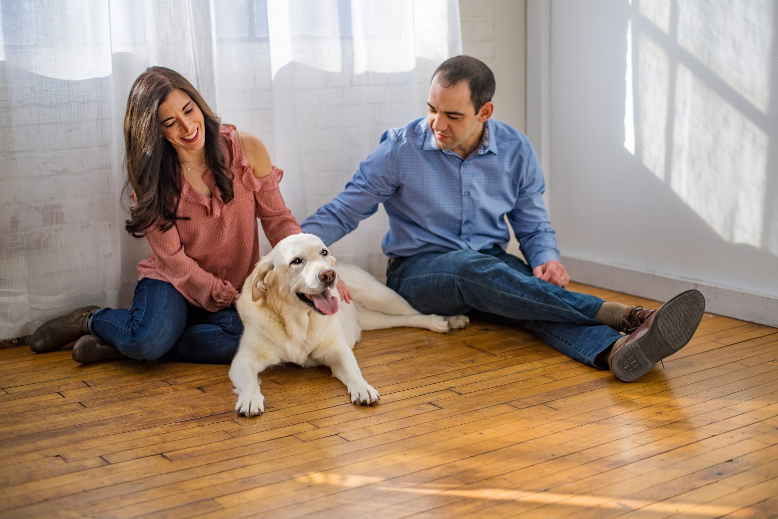 Man and Woman sitting on floor with dog. Senior dog Portait