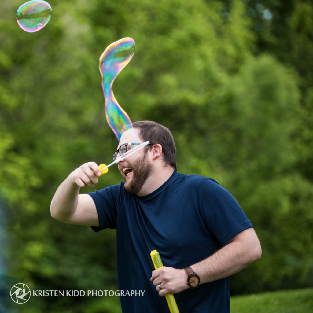 man playing with bubbles and laughing
