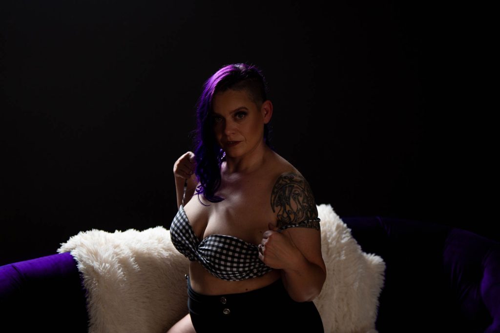 a boudoir photography of a curvy lady in a pattern bra and black short