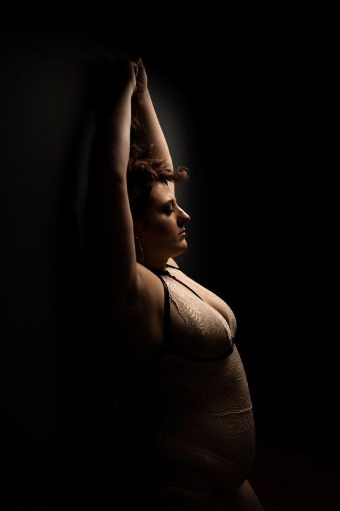 a lady taking a dark and light theme boudoir photography session in her lingerie