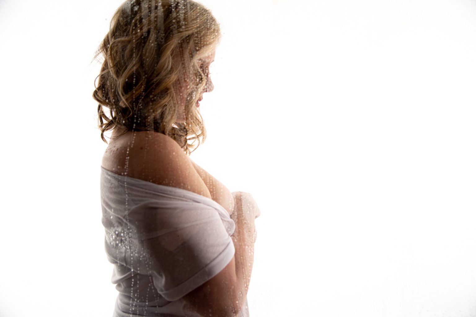 a blonde lady taking a boudoir photography with a white shirt or oversize white shirt